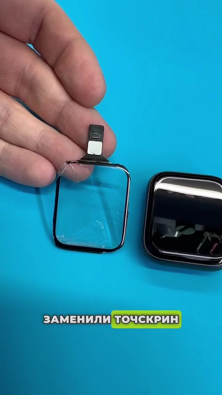 Apple Watch и снятое сенсорное стекло в руках мастера