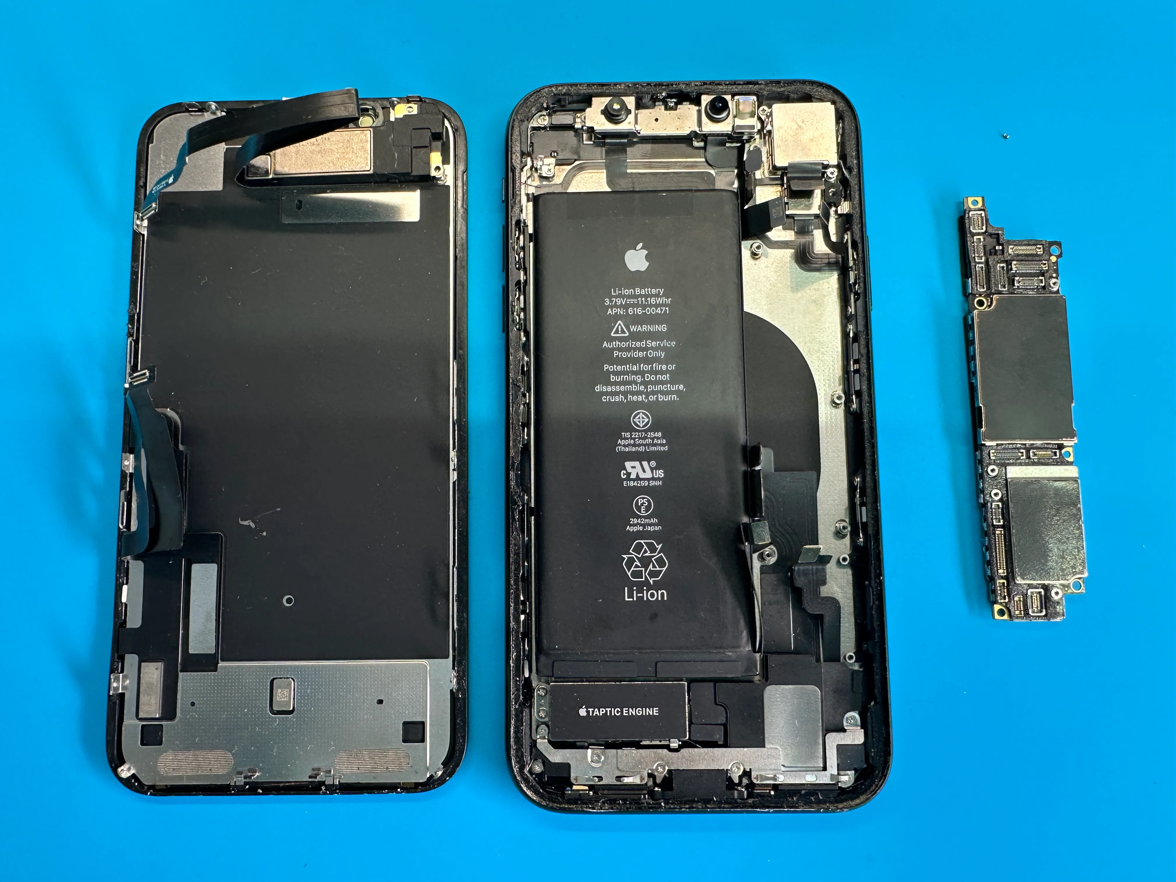 Открытый iPhone и снятая системная плата на рабочем столе